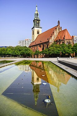 Germany, Berlin, Marienkirche, St Marys Church dating from the 13th Century, reflected in fountain pool.