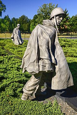 USA, Washington DC, National Mall, Korean War Veterans Memorial, Statues of soldiers on patrol in combat gear among juniper bushes.