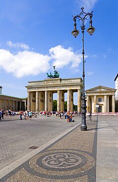 Germany, Berlin, Mitte, sightseeing tourists at the Brandenburg Gate or Brandenburger Tor in Pariser Platz leading to Unter den Linden and the Royal Palaces with the Quadriga of Victory on top. The only remaining of the original 18 gates in the Berlin Customs Wall.