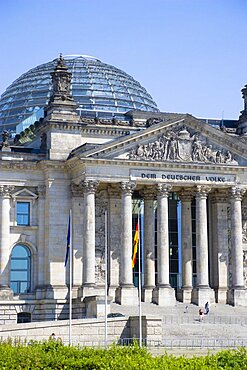 Germany, Berlin, Mitte, The Reichstag building in Tiergarten with the inscrption Dem Deucschen Volke, For the German People, on the facade above the columns at the entrance with Norman Foster's glass roof dome behind.