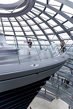 Germany, Berlin, Mitte, Tiergarten, interior of the glass dome on the top of the Reichstag building designed by architect Norman Foster with a double-helix spiral ramp around the mirrored cone that reflect light into the debating chamber of the Bundestag below. The top of the ramp here has the hot air vent from the debating chamber.