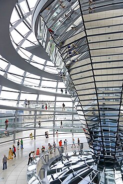 Germany, Berlin, Mitte, Tiergarten, interior of the glass dome on the top of the Reichstag building designed by architect Norman Foster with a double-helix spiral ramp around the mirrored cone that reflect light into the debating chamber of the Bundestag below.