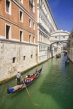 Italy, Venice, Doge's Palace and Bridge of Sighs with gondolas passing.