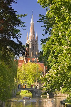 BELGIUM Bruges Canal scene with St Salvatorskathedraal  St Saviours Cathedral  in the background. People walking over bridge  boat and swans in the water. Holidays  Tourism  Travel  Flemish Region