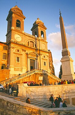 ITALY Lazio Rome Trinita dei Monti sixteenth century church at the top of the Spanish Steps at sunset with tourist crowds.