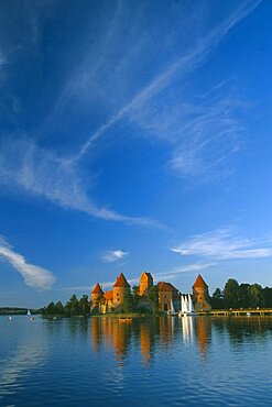 LITHUANIA  Trakai Wide angle view of castle reflected in lake with windswept clouds above