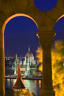 HUNGARY  Budapest Night time view of Parliament over the Danube from Fishermens Bastion  viewed through arches. Holidays Travel Tourism Neo Gothic Architecture Eastern Europe