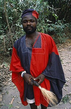 GHANA  Tribal People Portrait of traditional priest and healer in village near Accra wearing black and red robes.