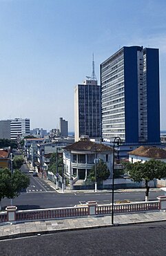 BRAZIL Amazonas Manaus Downtown area. View across a road towards a street of houses with high rise buildings behind Brasil