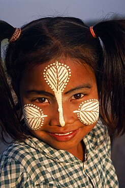 MYANMAR  Amarapura Head and shoulders portrait of young girl at U Bein Bridge near Mandalay wearing thanakha paste patterns on her face to beautify and protect skin from the sun. cosmetic made from tree bark. Burma