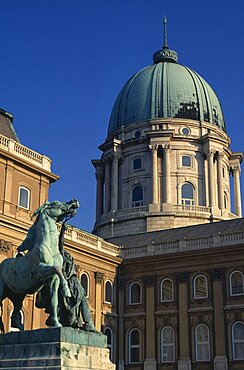 The Royal Palace part view of exterior and domed roof with statue of man restraining horse in the courtyard in foreground, Budapest, Hungary