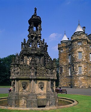 Holyrood Palace part view of western exterior with ornate carved stone fountain in the foreground, Edinburgh, Lothian, Scotland, United Kingdom