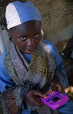 Portrait of a local child playing a hand held computer game, Kano, Nigeria, Africa