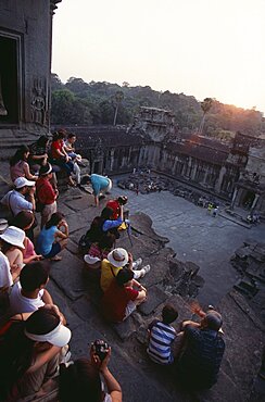 Tourists with cameras watching the sunset from the central sanctuary on the upper level, Angkor Wat, Siem Reap Province, Cambodia