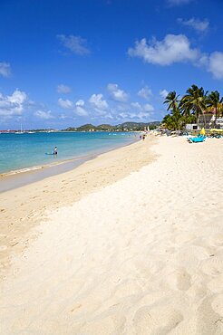 Reduit Beach in Rodney Bay with tourists in the water and on the beach with yachts at anchor in the bay, Gros Islet, St Lucia