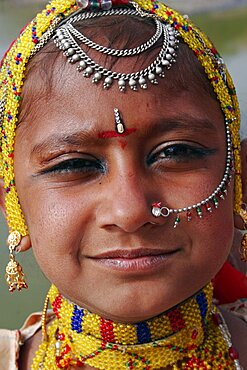 Portrait of a young Indian girl at Meherangarh Fort wearing nose ring and chain and traditional bead jewelery and black kohl eyeliner, Jodhpur, Rajasthan, India