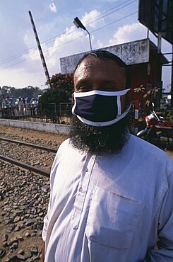 Bearded man wearing a mask covering his mouth and nose against air pollution, Bangladesh, Asia