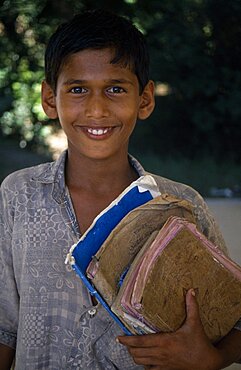 Portrait of boy holding school books, Bangladesh, Asia