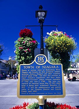 Canada, Ontario, Niagara on the Lake, Queen Street Plaque and hanging baskets.