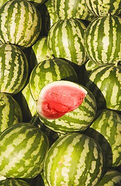 Turkey, Aydin Province, Kusadasi, Fresh watermelon on sale at town produce market with fruit at centre cut open to reveal red flesh and seeds