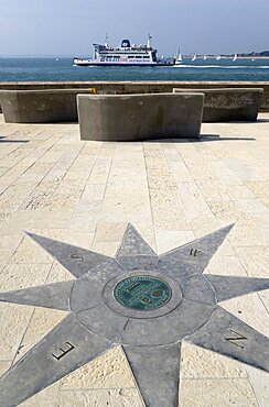 England, Hampshire, Portsmouth, A plaque within a compass on the Millenium Walk commemorating its opening by Prince Phillip The Duke of Edinburgh with an Isle Of Wight ferry passing through the harbour entrance.