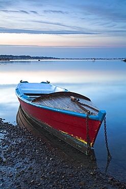 A small boat in Poole Harbour at dawn, Dorset, England, United Kingdom, Europe