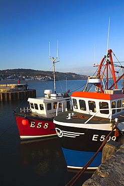 Fishing vessels moored safely to the Cobb in Lyme Regis Harbour, Lyme Regis, Dorset, England, United Kingdom, Europe