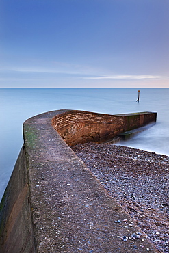 Stone jetty on Sidmouth beachfront at sunset, Sidmouth, Devon, England, United Kingdom, Europe