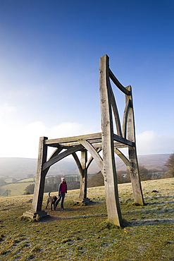 Dog walker gazes up at the Giants Chair sculpture in Dartmoor National Park, Devon, England, United Kingdom, Europe