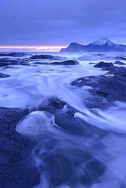 Surging waves rush over the basalt ledges of Gjogv at dawn, Eysturoy, Faroe Islands, Denmark, Europe