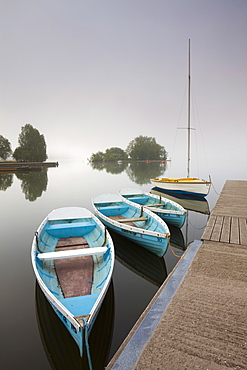 Pleasure boats moored at Llangorse Lake on a misty morning, Brecon Beacons National Park, Powys, Wales, United Kingdom, Europe