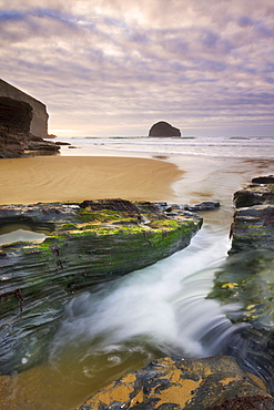 Freshwater stream flows through a channel towards the beach at Trebarwith Strand, Cornwall, England, United Kingdom, Europe