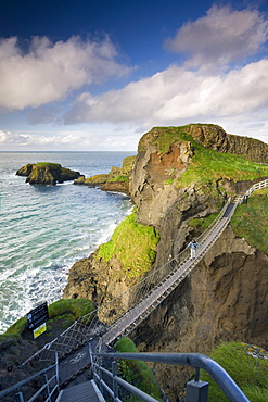 Young woman crossing Carrick-a-Rede rope bridge on the Causeway Coast, County Antrim, Ulster, Northern Ireland, United Kingdom, Europe