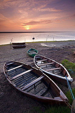 Boats at low tide on the shore of The Fleet lagoon, Chesil Beach, Dorset, England, United Kingdom, Europe