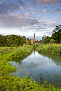 Burford Church spire reflected in the River Windrush watermeadows, Burford, The Cotswolds, Oxfordshire, England, United Kingdom, Europe