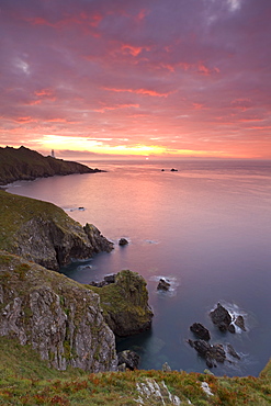 Glorious sunrise off the coast of Start Point, with the lighthouse on the distant headland, South Hams, Devon, England, United Kingdom, Europe