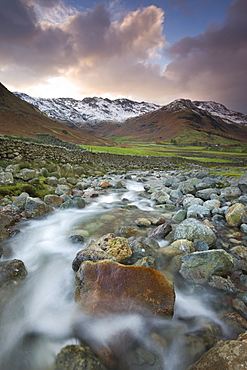 Redacre Gill river tumbling over rocks towards the snow capped mountains surrounding Great Langdale, Lake District National Park, Cumbria, England, United Kingdom, Europe