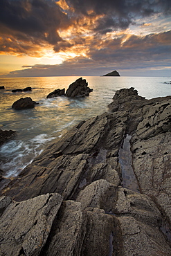 Sunset on the rocky ledges at Wembury Bay looking towards the Great Mewstone, Devon, England, United Kingdom, Europe