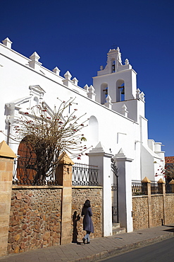 Woman walking past Iglesia de Santo Domingo, Sucre, UNESCO World Heritage Site, Bolivia, South America