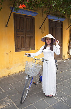 Woman wearing Ao Dai dress with bicycle, Hoi An, Quang Nam, Vietnam, Indochina, Southeast Asia, Asia