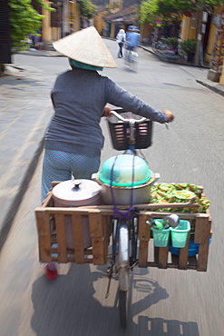 Woman vendor pushing bicycle along street, Hoi An, Quang Nam, Vietnam, Indochina, Southeast Asia, Asia