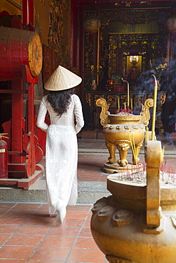 Woman wearing ao dai dress at Ha Chuong Hoi Quan Pagoda, Cholon, Ho Chi Minh City, Vietnam, Indochina, Southeast Asia, Asia