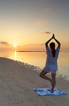 Woman practising yoga at sunrise, Rasdhoo Island, Northern Ari Atoll, Maldives, Indian Ocean, Asia