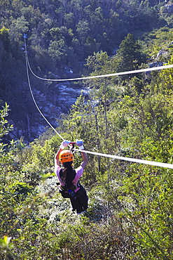 Woman sliding down a zip-line, Storms River, Eastern Cape, South Africa, Africa