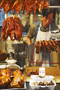 Man selling roast chicken and duck at market, Causeway Bay, Hong Kong, China, Asia