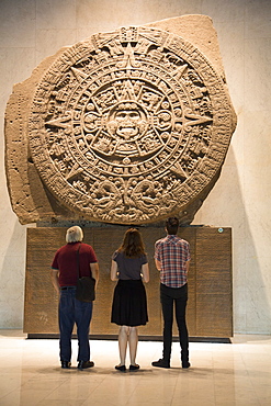 Tourists looking at Aztec calendar stone, National Museum of Anthropology, Mexico City, Mexico, North America