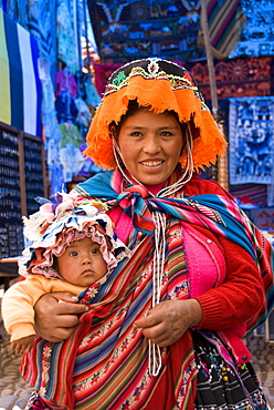 Indigenous mother with child in traditionally colorful dress, Pisac, Sacred Valley, Peru, South America