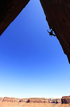 A rock climber tackles an overhanging wall on the cliffs of Indian Creek, a famous rock climbing area near Moab, south eastern Utah, United States of America, North America