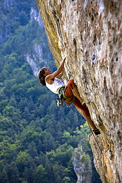 Rock climber tackles a very overhanging route on the famous limestone cliffs of the Gorge du Tarn in the Massif Central, near Millau and Rodez, south west France, Europe