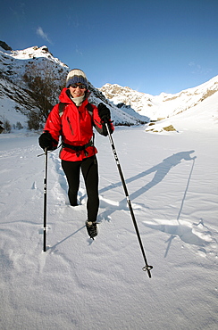 A trekker heads up into the wilderness of the highest part of the Ecrins Massif in deep winter snow, above the village of Pelvoux, near Briancon, western Alps, Hautes Alpes, south west France, Europe